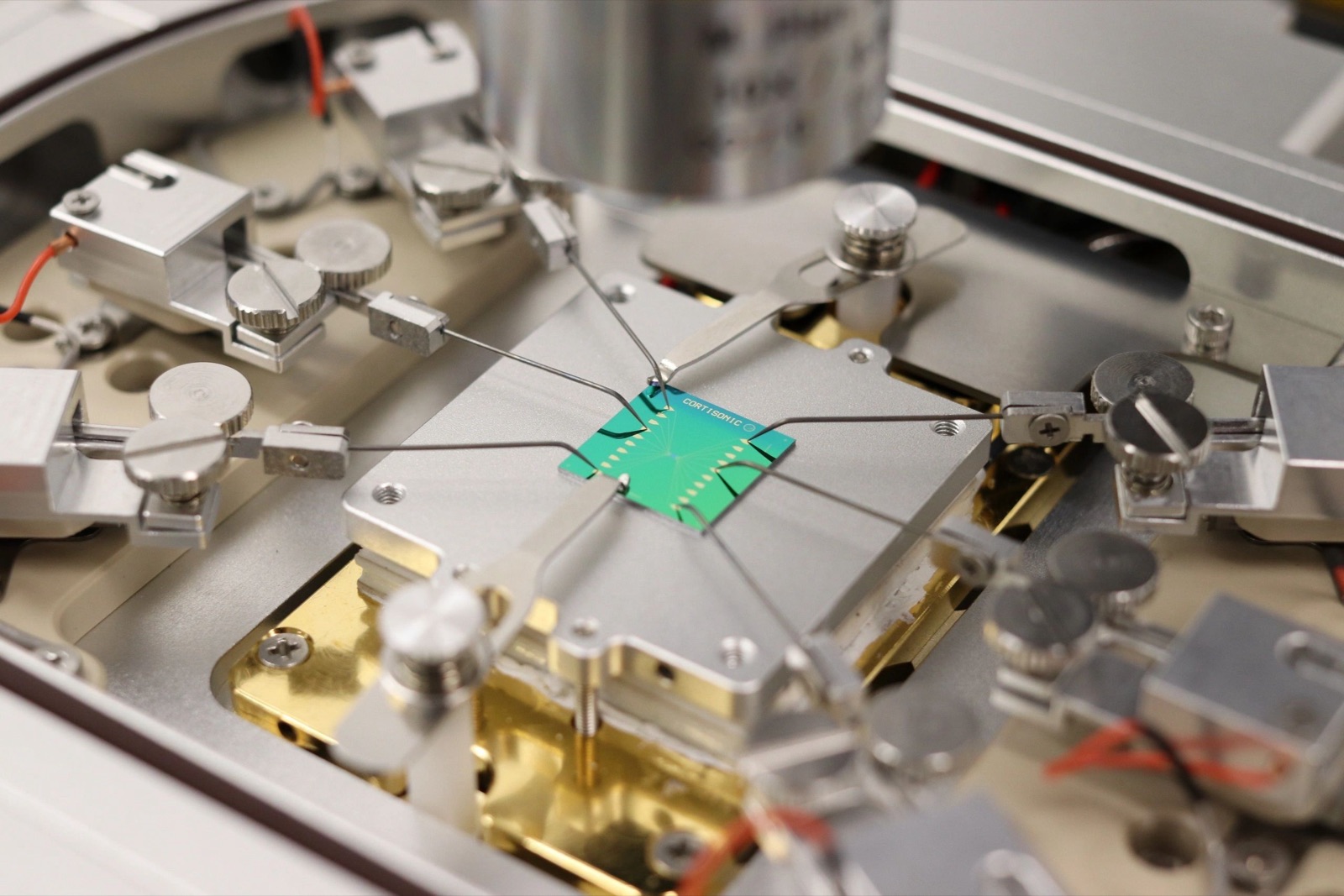 A Cortisonic chip mounted on a probe station with needle probes contacting its pads